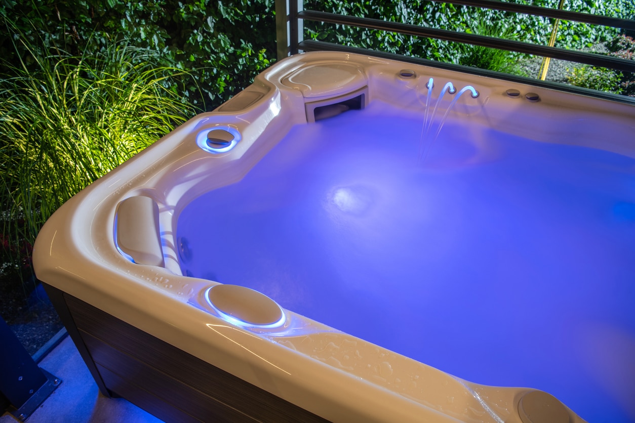 A glowing purple hot tub at night, part of Nejame & Sons’ selection of hot tubs for sale in Carmel, NY.