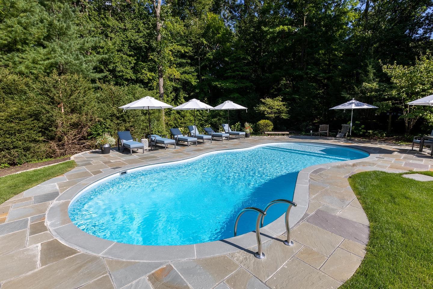 Sleek gray hot tub on an outside patio in front of steps with a small seating area. Family sized hot tub in New Fairfield, CT.